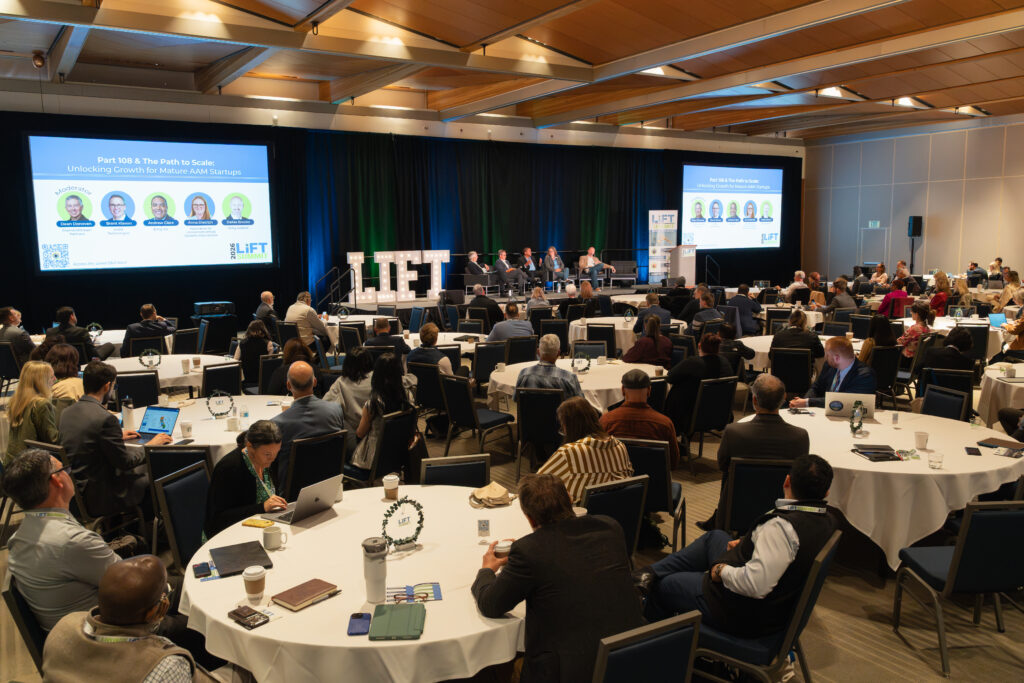 Attendees seated at round tables during a panel session at the LIFT Summit