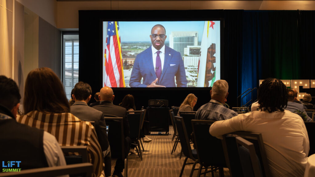 Attendees watching a keynote address on the main screen at the LIFT Summit